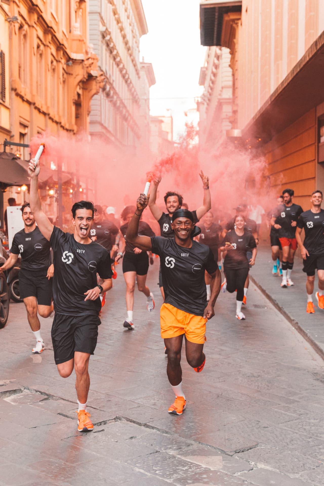 Runners celebrating through Florence streets with pink smoke